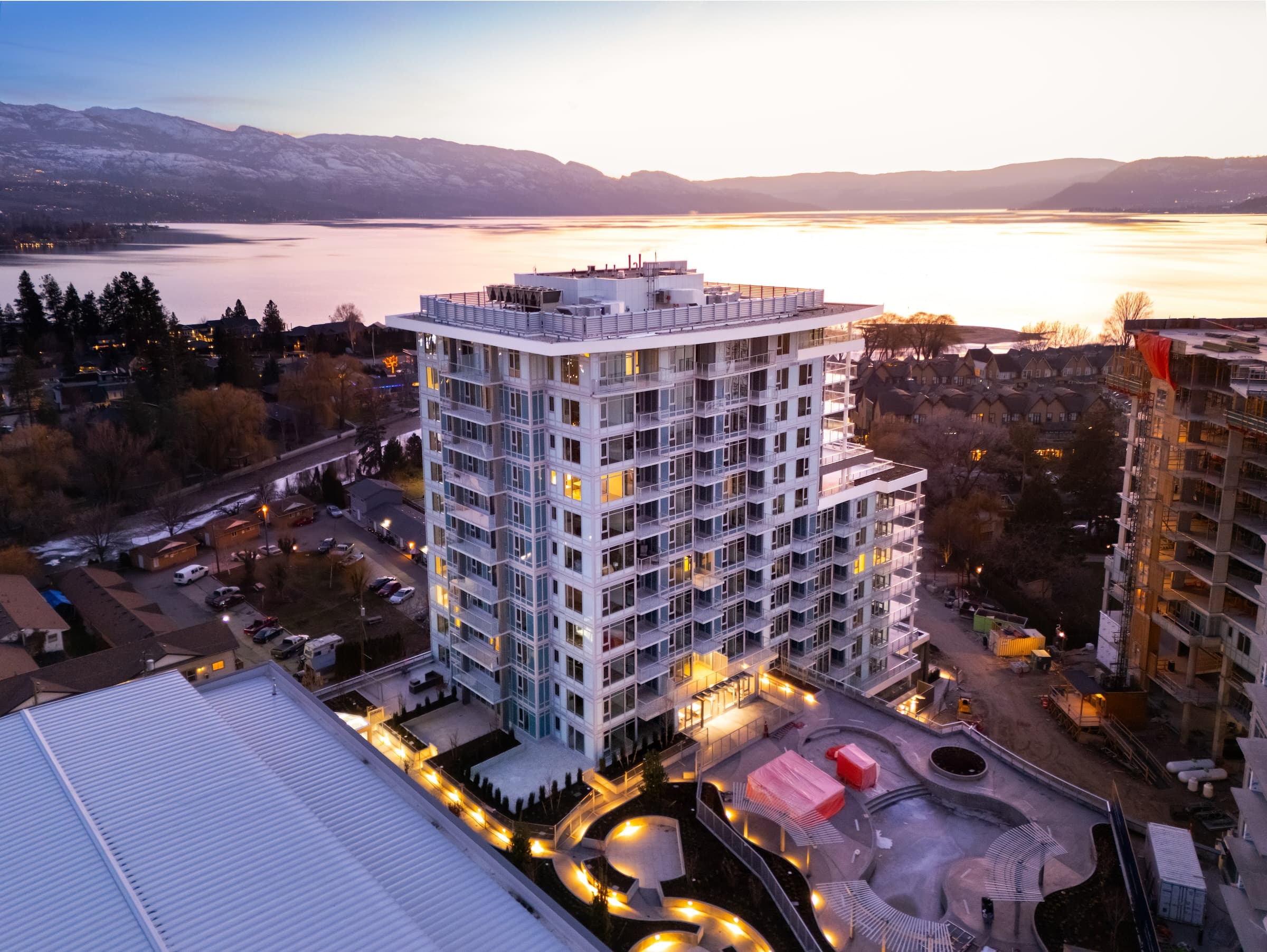 Aqua building at sunset with Okanagan Lake and mountains